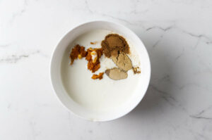 Mixing cream with pumpkin puree and spices.