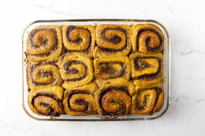 Freshly baked pumpkin swirl buns in a baking dish.