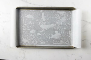 A jelly roll pan lined with parchment paper.