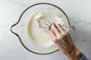 Whipping eggs and sugar to a thick ribbon stage.