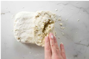 Folding biscuit dough to create layers.