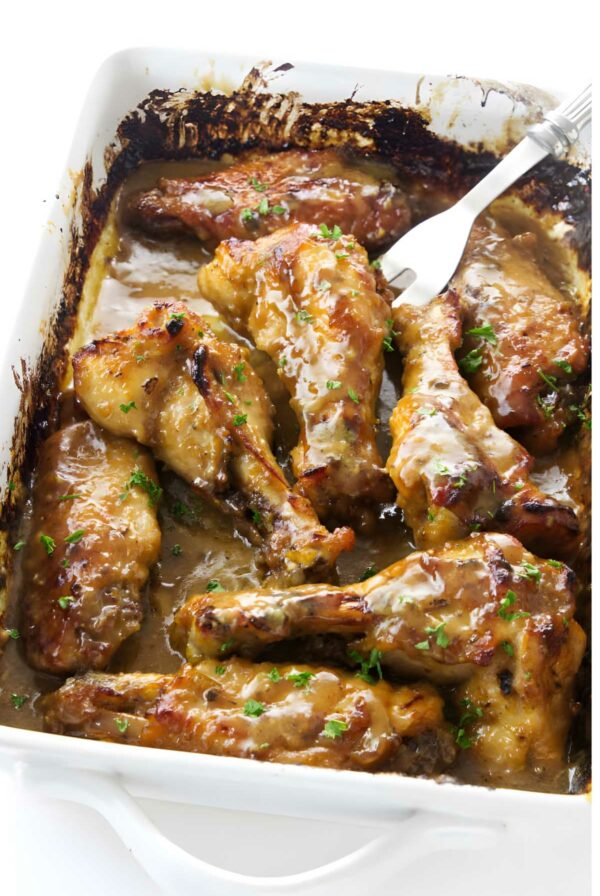 Glazed turkey wings in white dish, garnished with parsley.