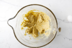 Blending sugar and butter in a mixing bowl.