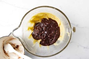 Adding the softened dates to the cake batter.