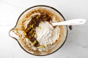 Mixing apples and the dry ingredients into the batter.