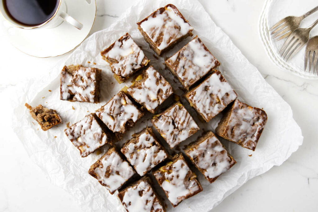 Slices of apple and date cake next to a cup of coffee.