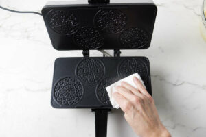 Adding oil to a pizzelle iron.
