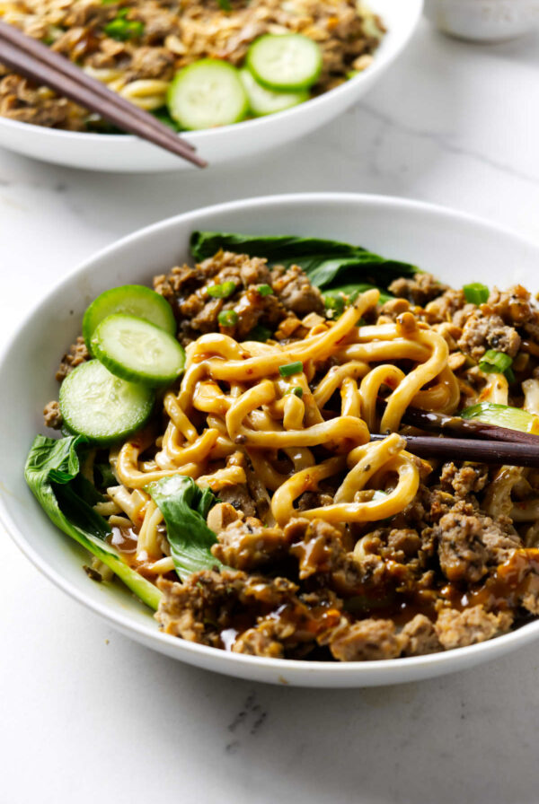 Szechuan dan dan noodles in a bowl with extra sauce drizzled over the top.