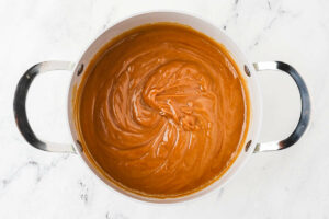 Warm peanut butter icing in a pot.