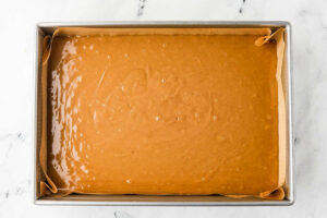 Spreading batter for easy peanut butter cake recipe in a sheet pan.