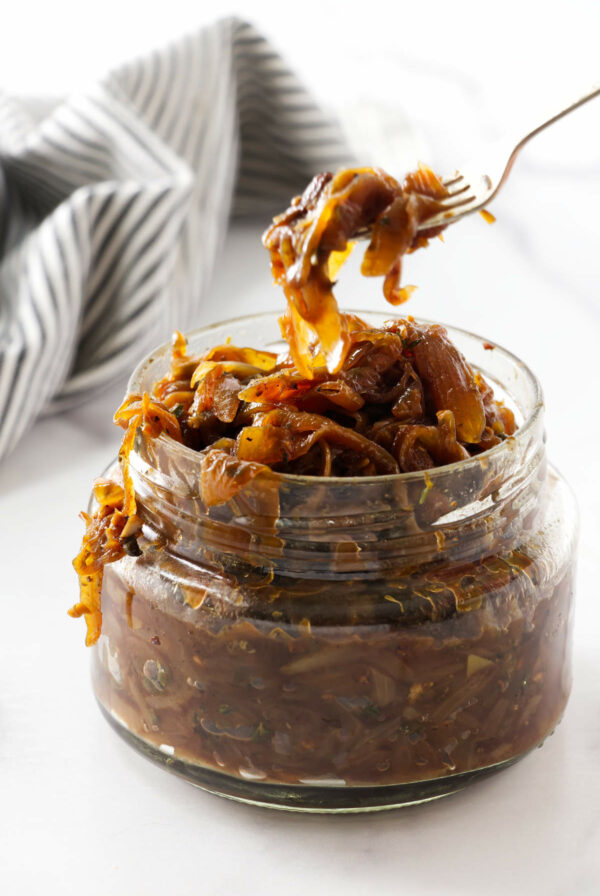 Scooping onion marmalade out of a jar.