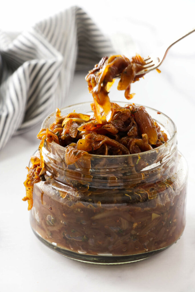 Scooping onion marmalade out of a jar.