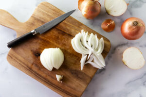 Slicing onions on a cutting board.