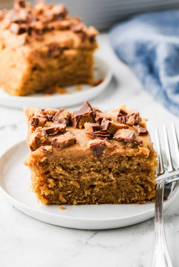 A fork on a plate with a slice of peanut butter sheet cake.