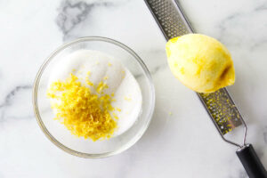 Mixing lemon zest with granulated sugar.