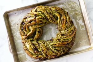 A freshly baked pistachio babka wreath on a baking sheet.