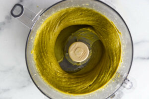 A food processor with freshly blended pistachio butter.