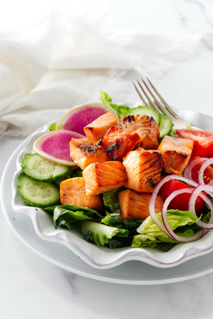 Chunks of salmon bites on a salad.