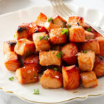 Chunks of salmon bites on a serving plate.