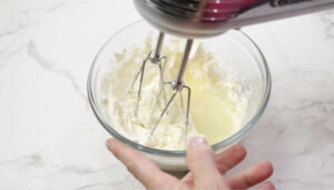 Mixing cream cheese with lemon juice and seasoning.