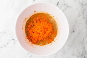 Adding grated apples and carrots to the muffin batter.