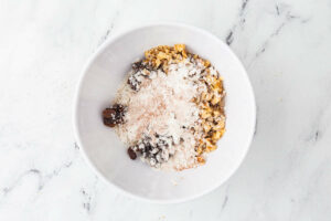 Tossing the raisins and nuts with flour.