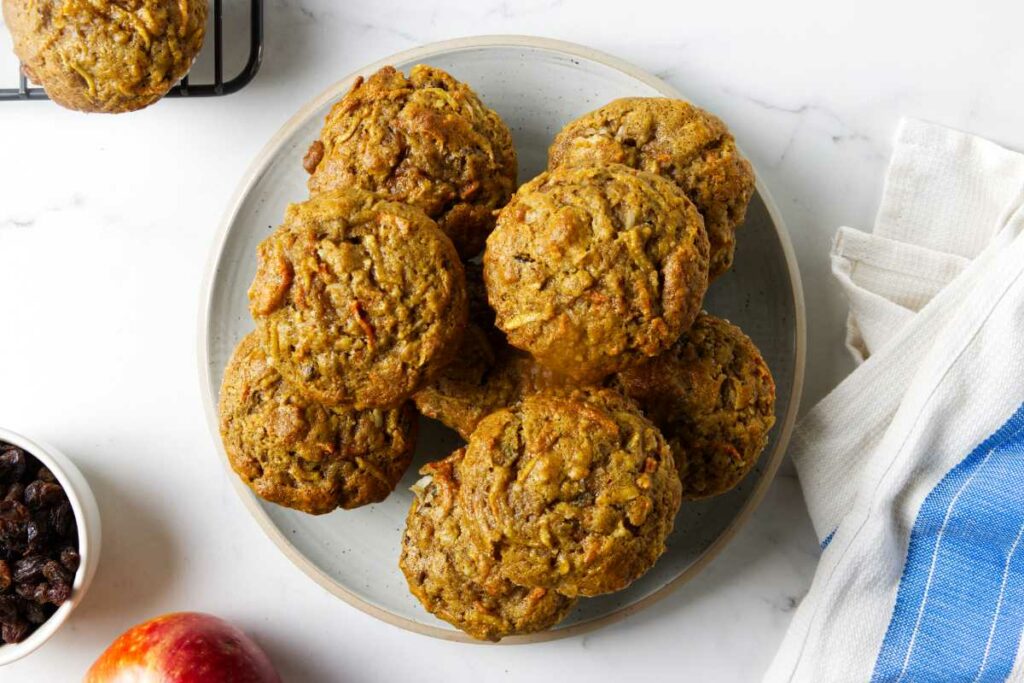 A stack of carrot apple breakfast muffins on a plate.