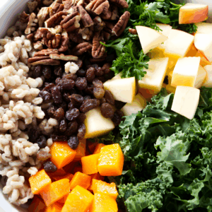 Bowl of apples, pecans, raisins, barley, kale, parsley, and roasted squash.