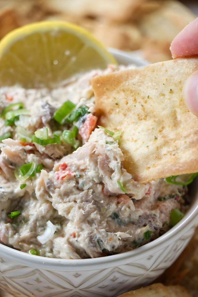 Cracker dipped in smoked salmon spread. 