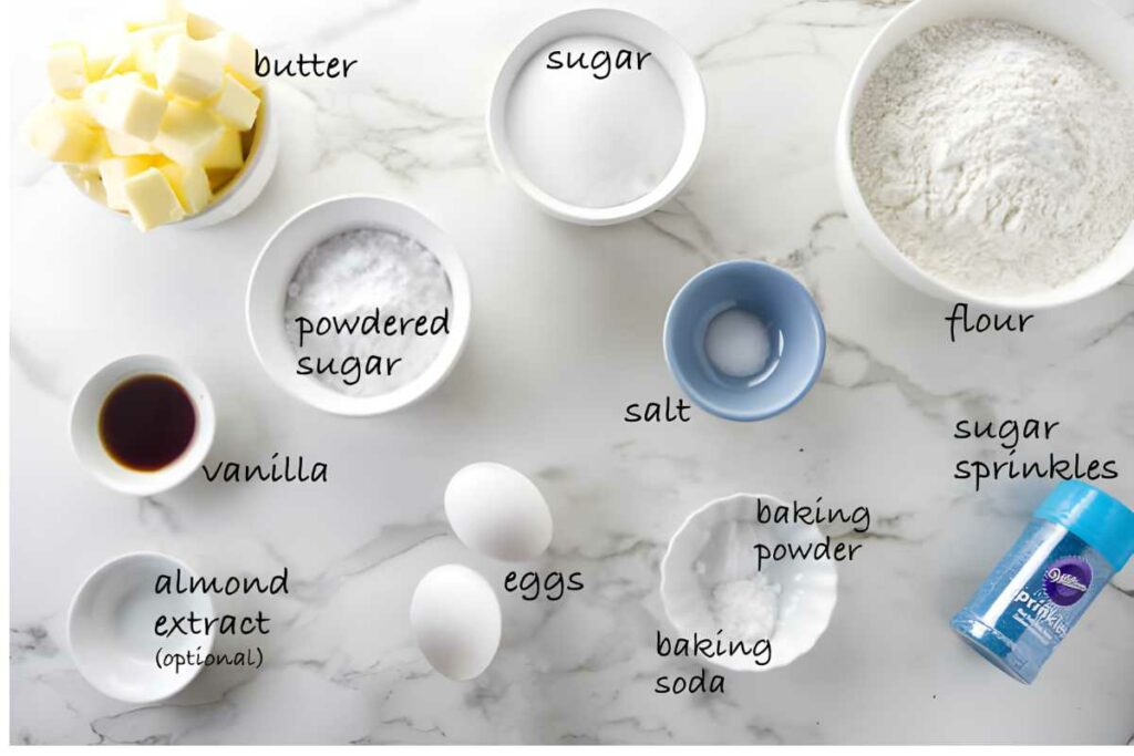 Overhead shot of assorted baking ingredients, including labeled butter, flour, eggs, and sugar.