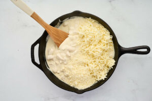 Stirring cheese into the pasta bake.