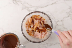 Adding marinade to chicken.