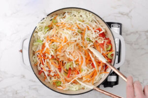 Adding the veggies to the skillet.
