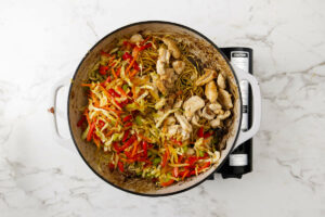 Adding the chicken and veggies back to the skillet.