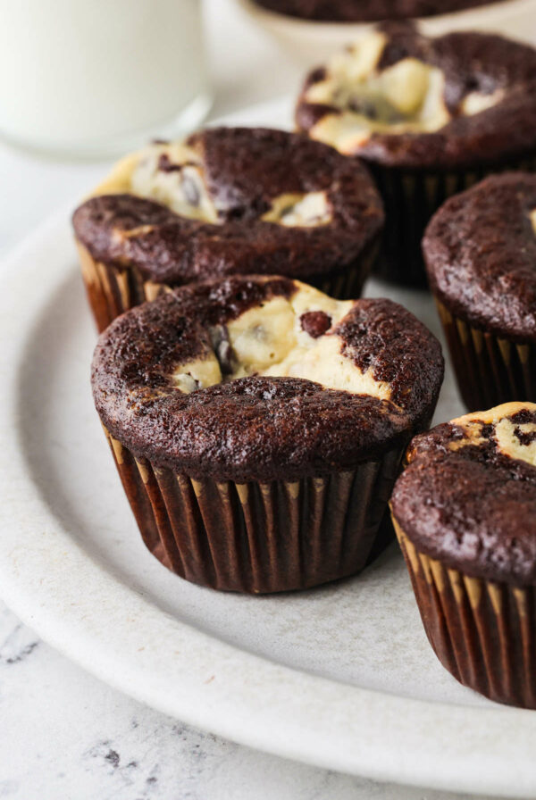 Five cream cheese filled cupcakes on a white plate.