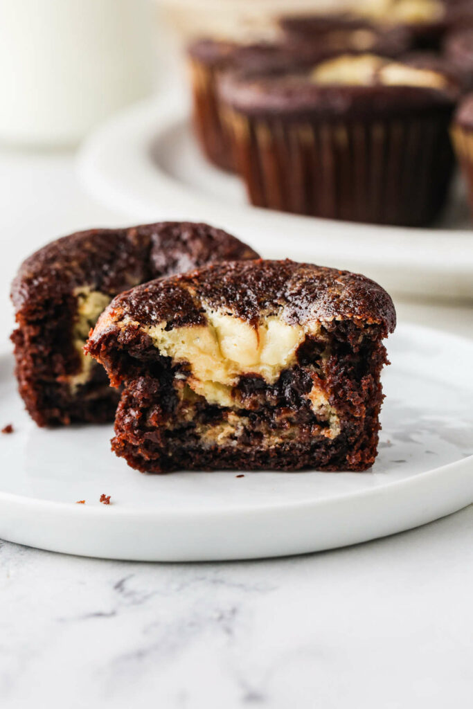 A cupcake cut in half showing cream cheese in the center.