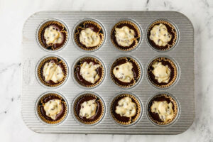 Adding cream cheese filling to the chocolate cupcakes.