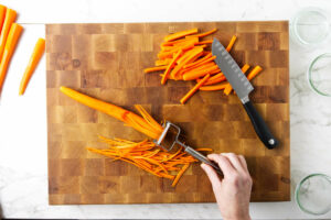 Slicing carrots into strips.