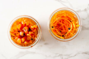Two jars of pickled carrots sliced in different thicknesses.