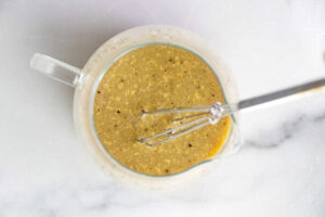 Whisking warm bacon dressing in a jar.