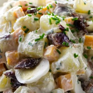 Creamy potato salad with eggs, bacon, cheddar, and chives.
