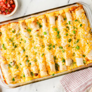 A hot breakfast enchilada casserole in a glass baking dish.