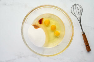 Whisking eggs and sugar with oil.