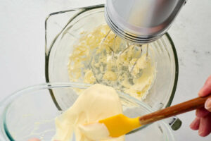 Adding melted white chocolate to buttercream.