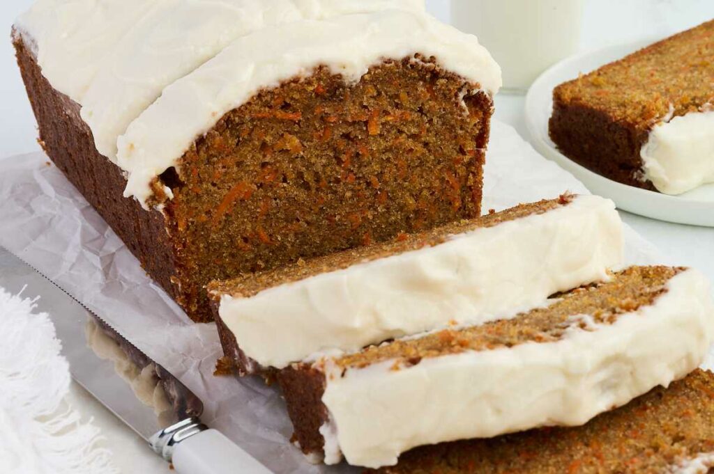 A carrot cake loaf topped with white frosting.