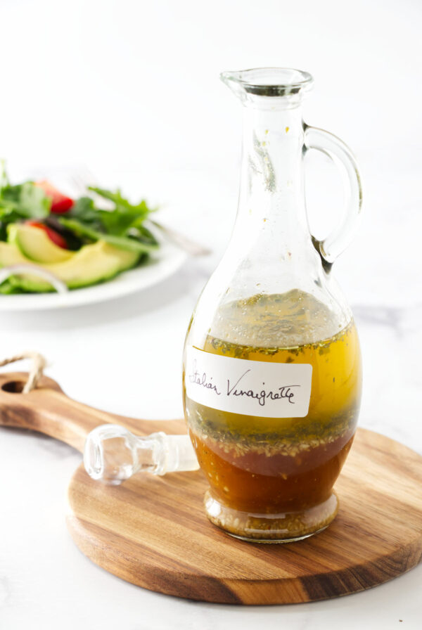 A salad behind a bottle of homemade vinaigrette.