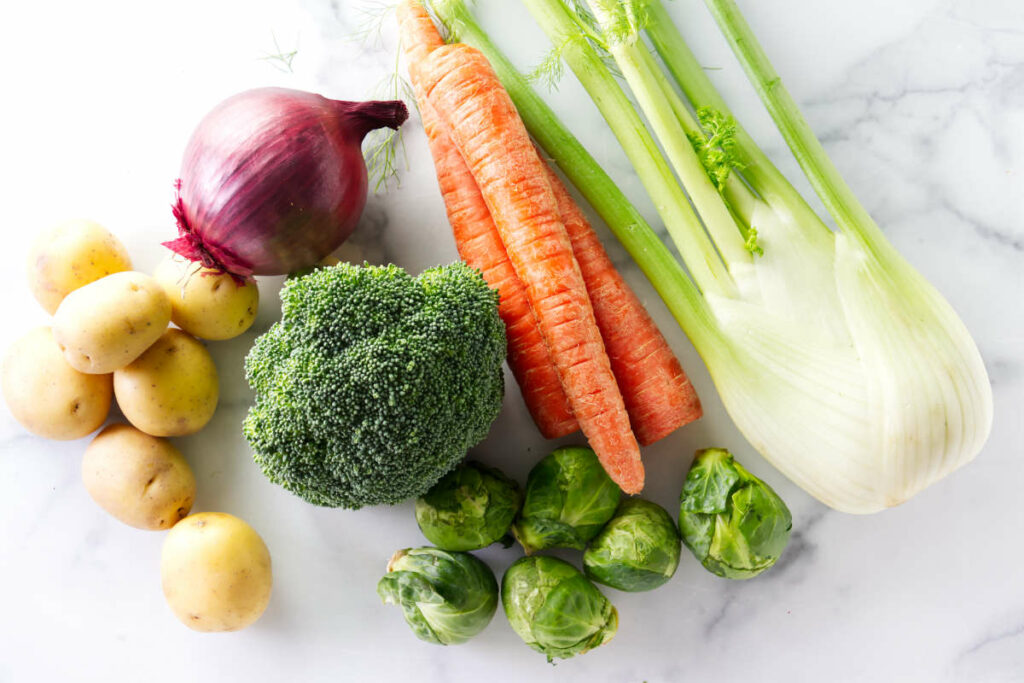 Assorted vegetables arranged on a marble countertop.