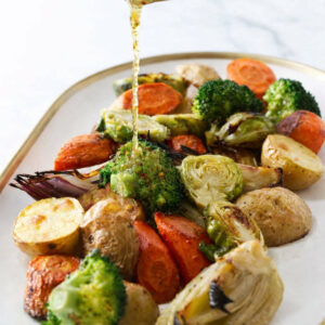 Drizzling Italian vinaigrette over roasted mixed veggies.