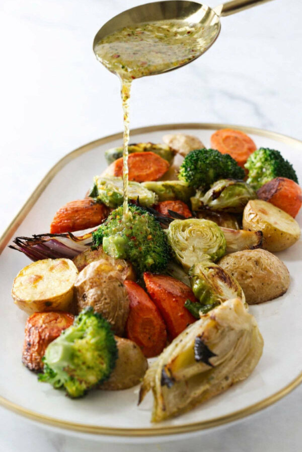 Drizzling Italian vinaigrette over roasted mixed veggies.