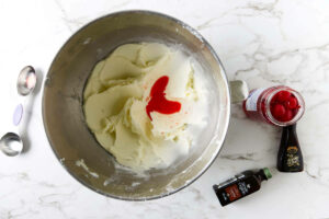 Adding extracts and cherry juice to the buttercream.